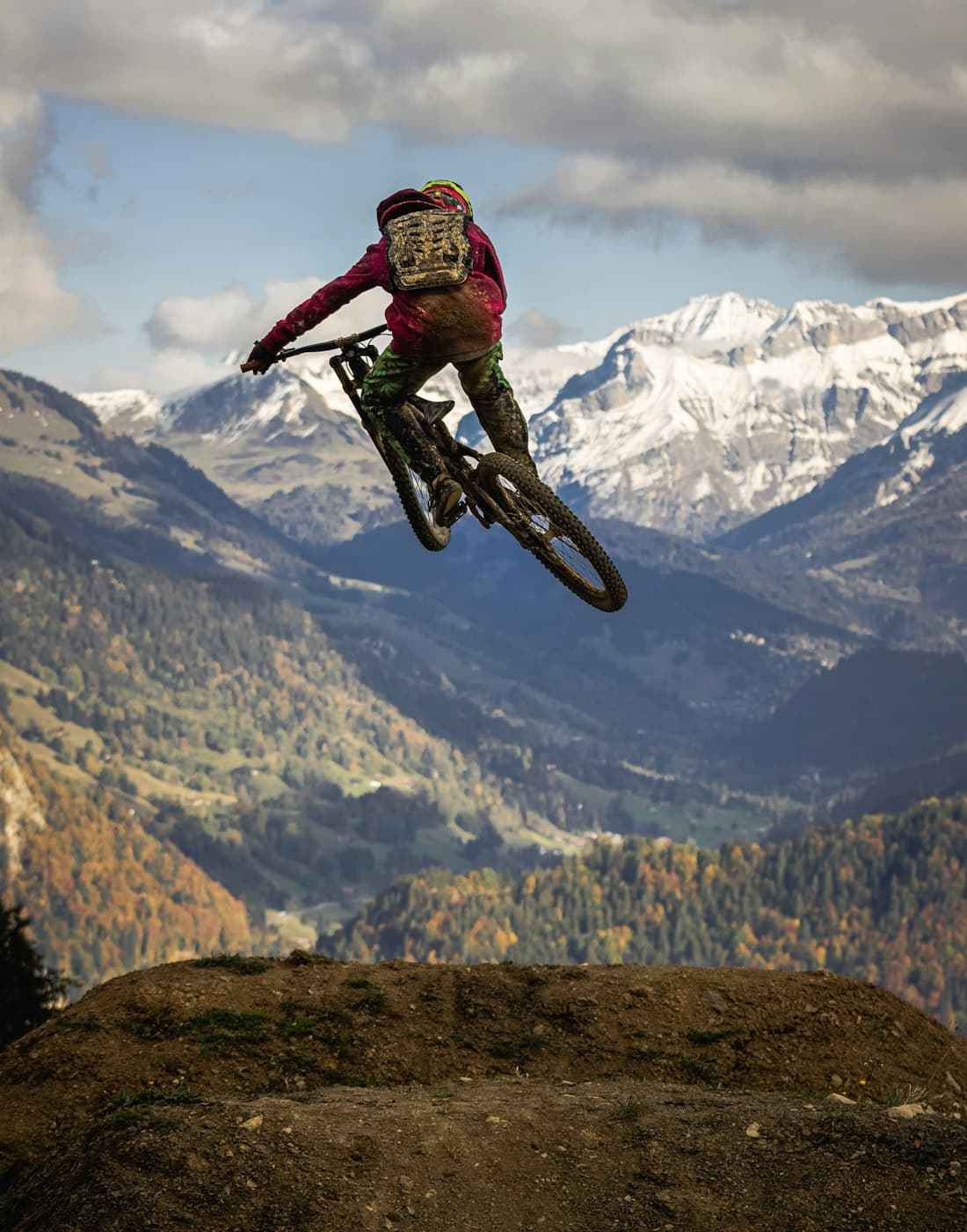 Ciclista saltando de mountain bike nas montanhas