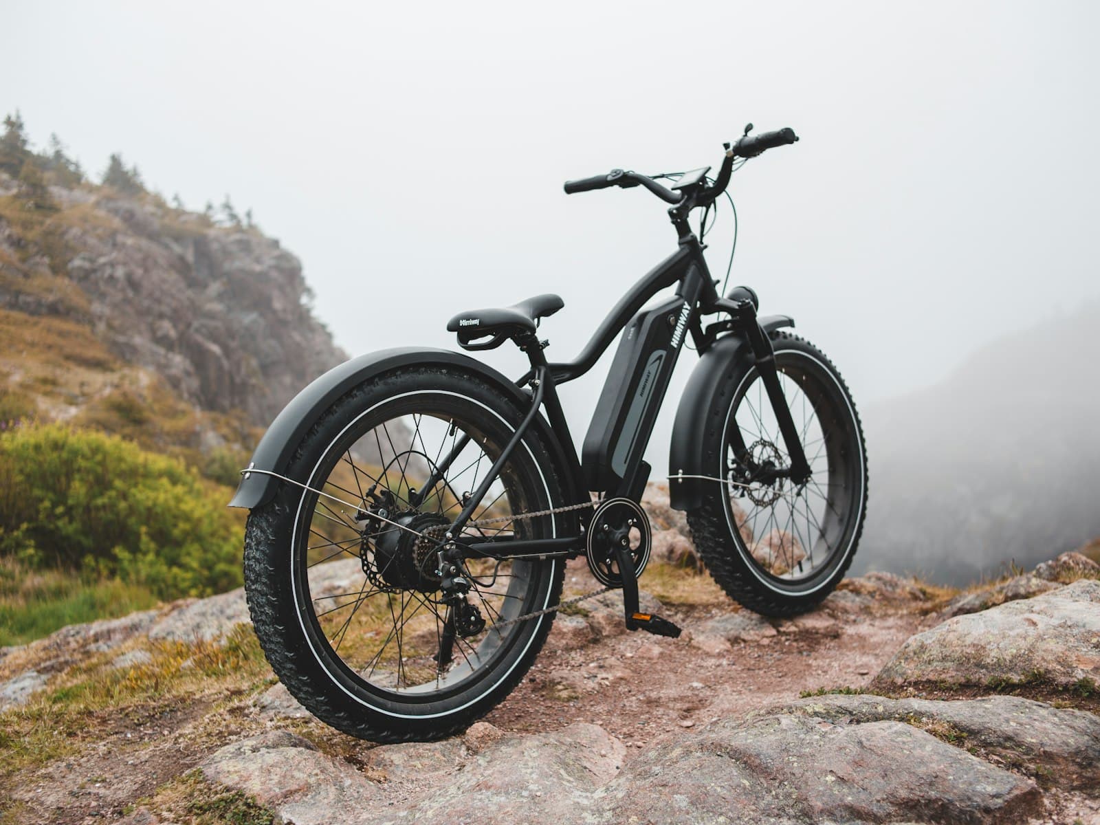 Bike elétrica de pneu largo estacionada nas pedras à beira-mar