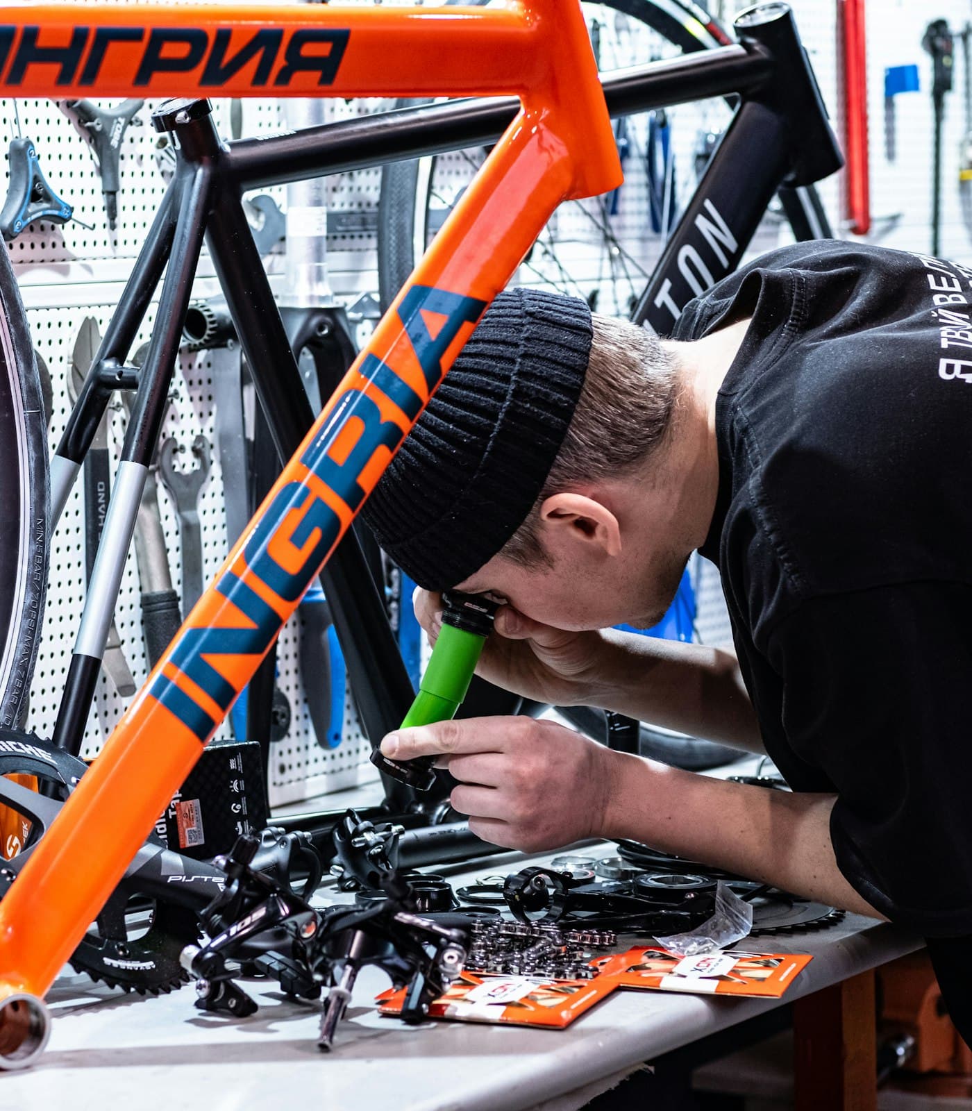 Mecânico ajustando uma bike laranja na oficina